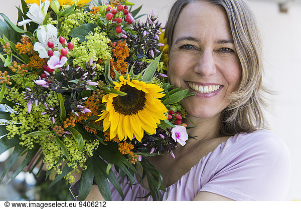 Portrait of mid adult woman with bouquet  smiling