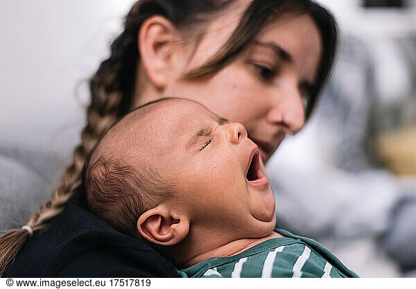 Portrait of mother and baby. Baby yawning