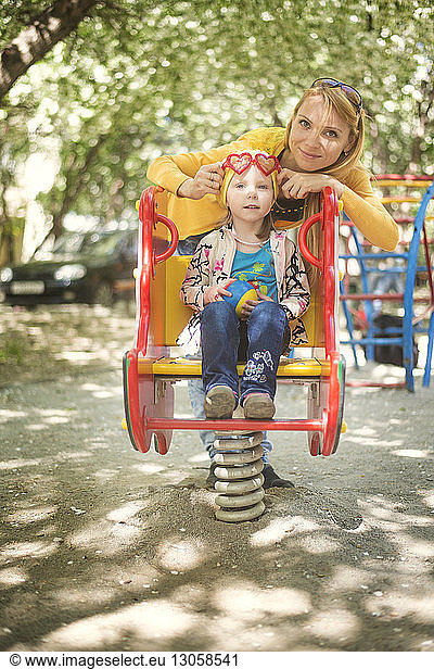 Portrait of mother and daughter on spring ride at park
