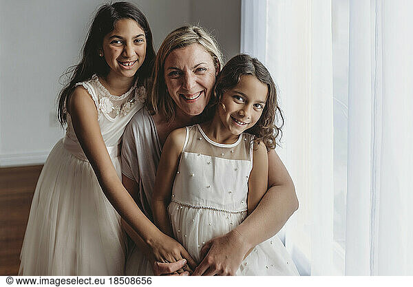 Portrait of mother and daughters smiling at camera in studio