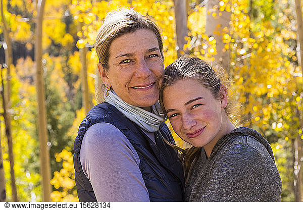 portrait of mother and her 13 year old daughter with autumn aspens in background
