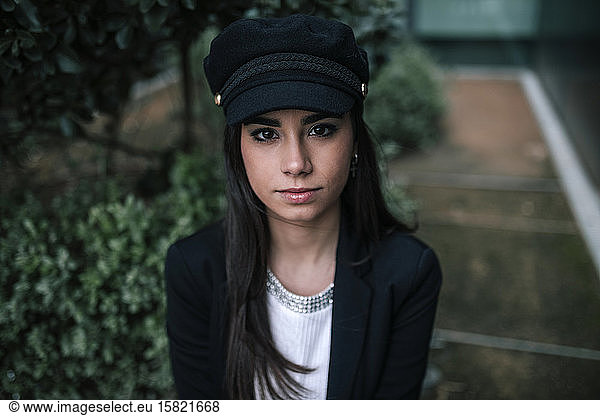 Portrait of pensive young woman wearing black cap