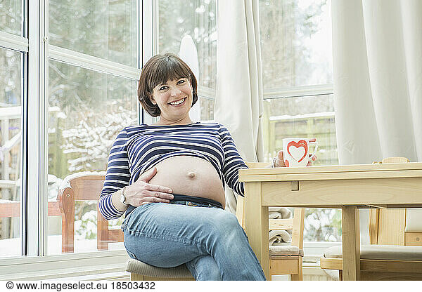 Portrait of pregnant woman sitting on chair