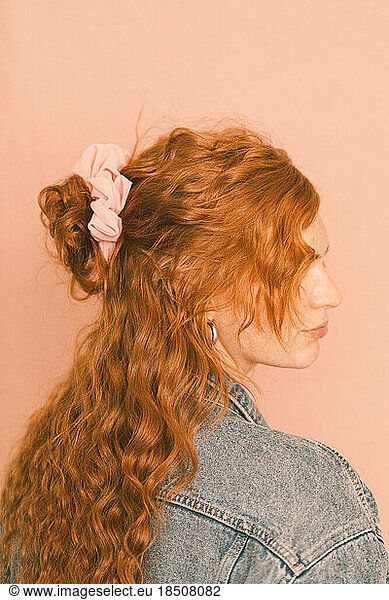 Portrait of redhead woman in levi jacket with pink scrunchie in