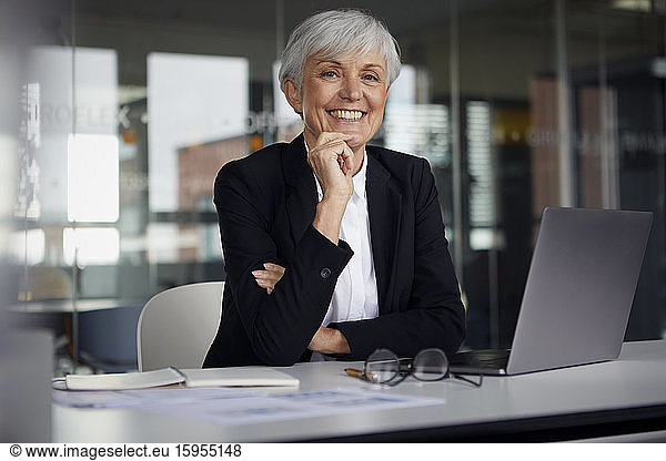 Portrait of relaxed senior businesswoman at desk in her office