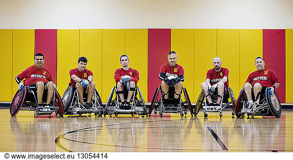 Portrait of rugby players on wheelchairs in court