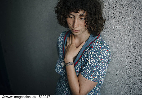 Portrait of sad young woman leaning against wall