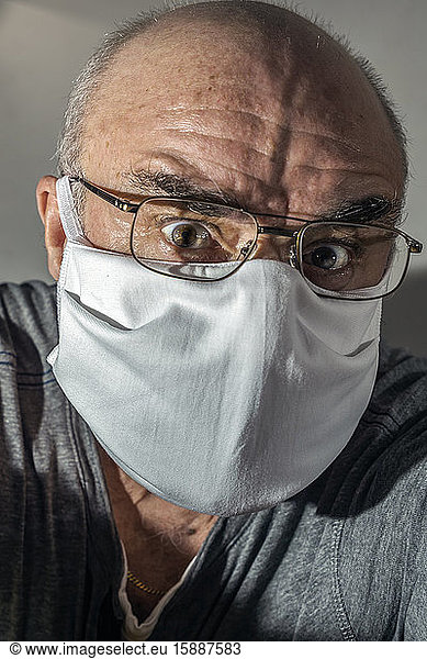 Portrait of senior man with surgical mask in panic