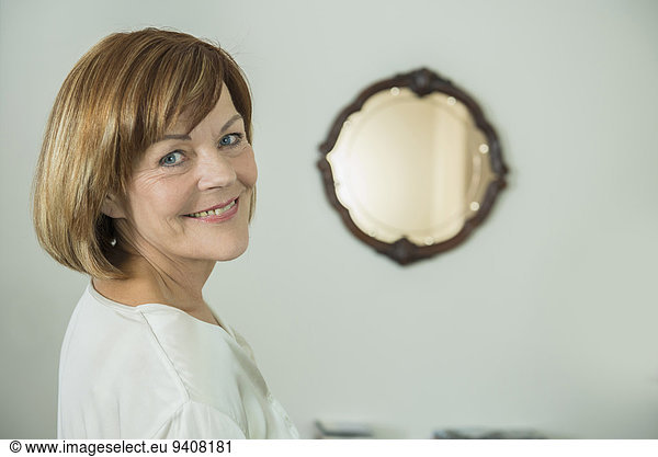 Portrait of senior woman in front of mirror  smiling