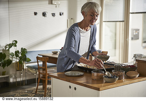Portrait of senior woman preparing granola