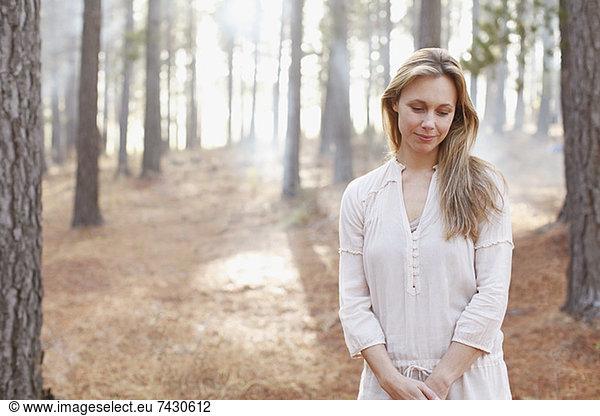 Portrait of serene woman in sunny woods