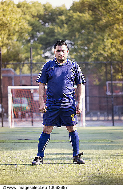 Portrait of serious soccer player standing at field