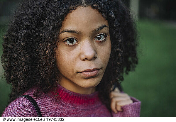 Portrait of serious teenage girl with curly hair