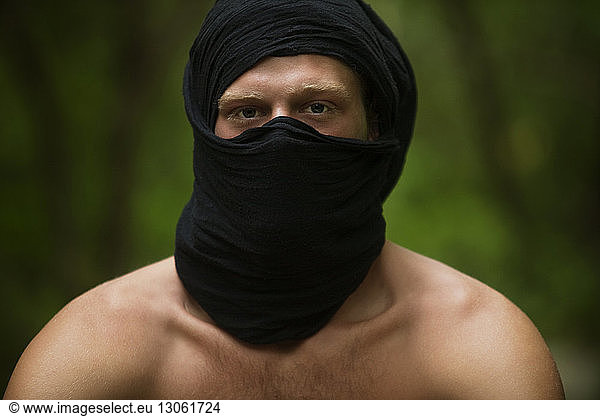Portrait of shirtless man wearing black scarf