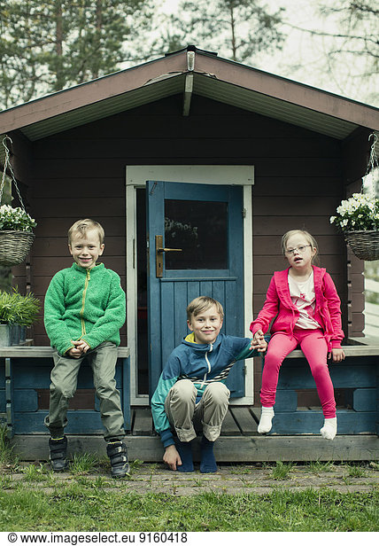 Portrait of siblings sitting on porch