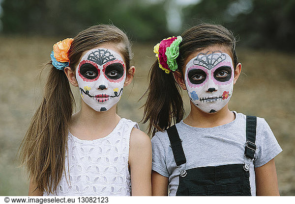 Portrait of sisters with face paint during Halloween