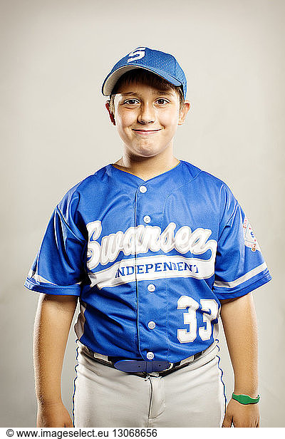 Portrait of smiling baseball player against white background