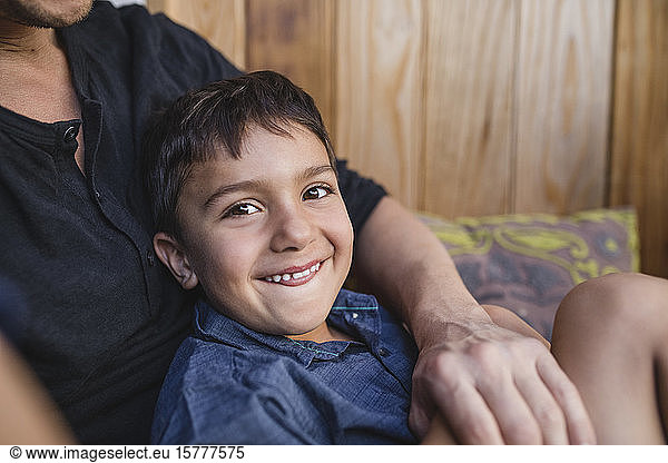 Portrait of smiling boy sitting with father