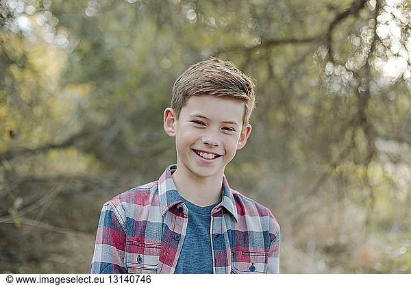 Portrait of smiling boy standing at park