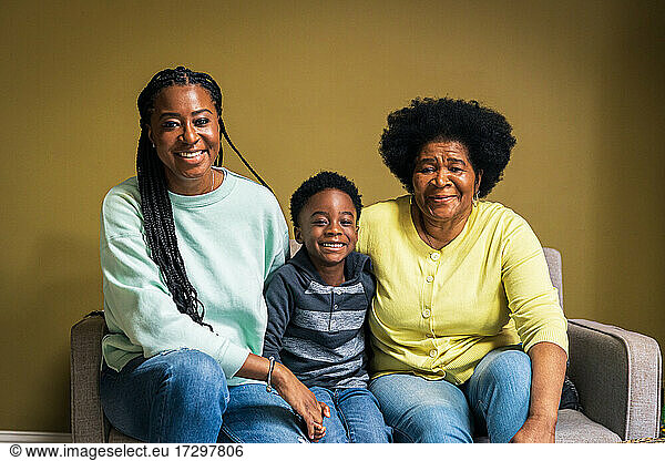Portrait of smiling boy with mother and grandmother at home