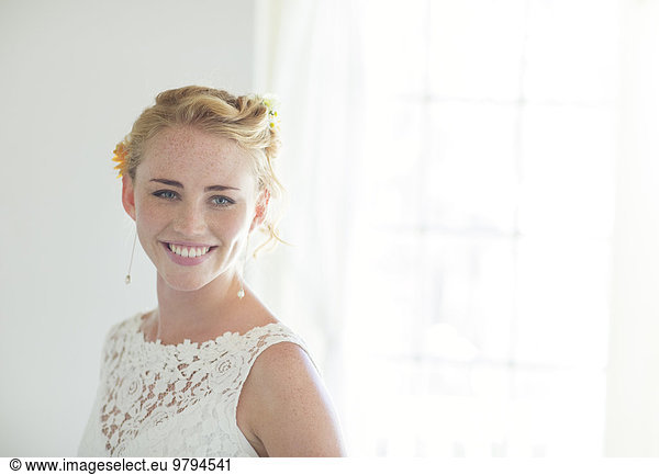 Portrait of smiling bride in sunny room