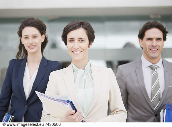 Portrait of smiling business people holding files