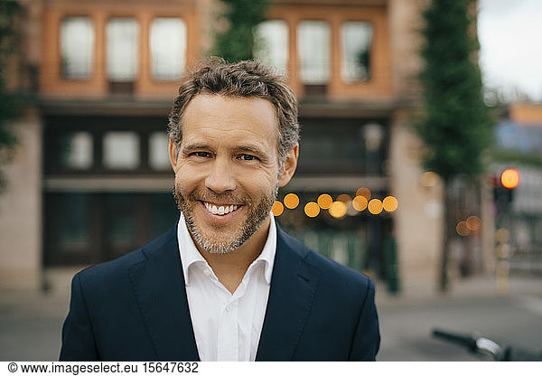 Portrait of smiling businessman in city