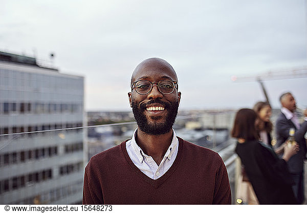 Portrait of smiling businessman wearing eyeglasses enjoying at office party