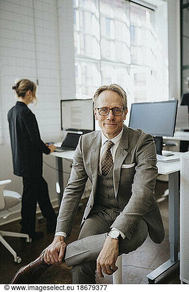 Portrait of smiling businessman wearing eyeglasses sitting at office