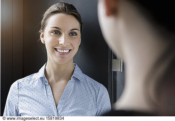 Portrait of smiling businesswoman meeting colleague in office