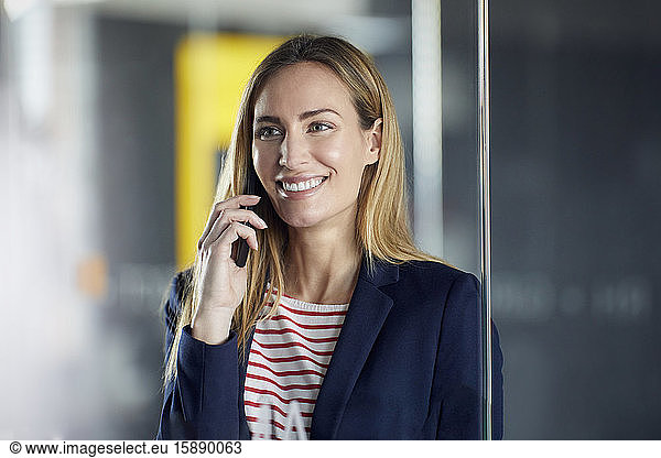 Portrait of smiling businesswoman on the phone in office