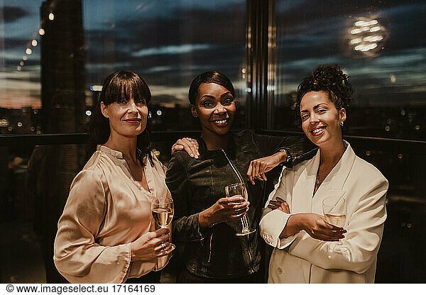 Portrait of smiling businesswomen with wineglasses during office party