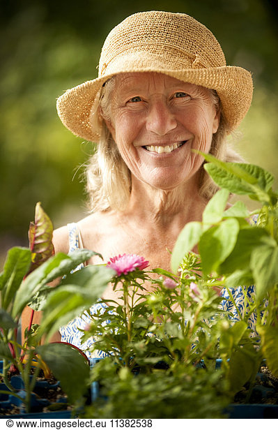 Portrait of smiling Caucasian woman holding tray of flowers