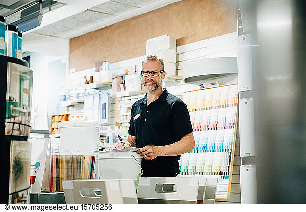 Portrait of smiling employee working in hardware store