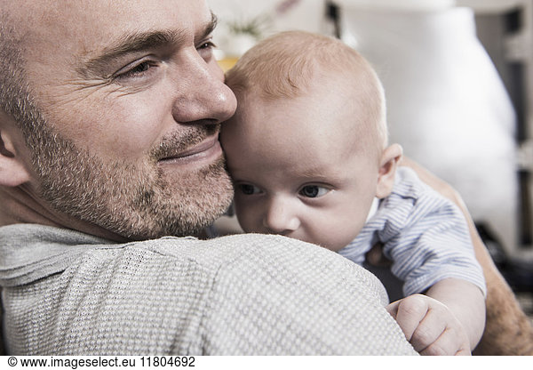Portrait of Smiling father holding baby boy in his arms