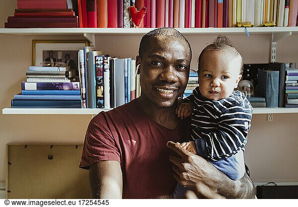 Portrait of smiling father with baby boy at home