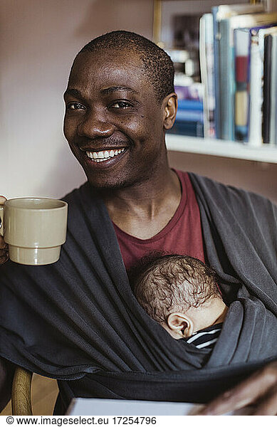 Portrait of smiling father with coffee cup at home