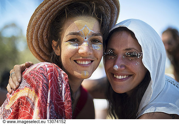 Portrait of smiling friends with face paint at traditional event