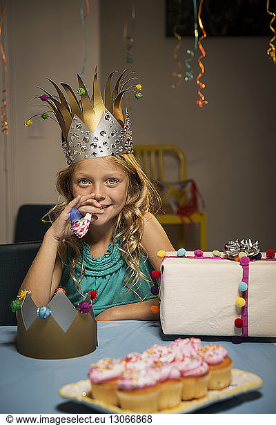 Portrait of smiling girl holding party horn blower