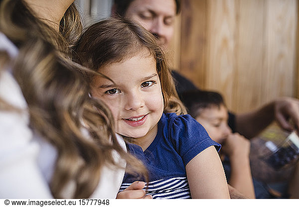 Portrait of smiling girl sitting with family