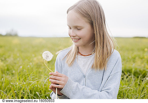 Portrait of smiling girl with dandelion
