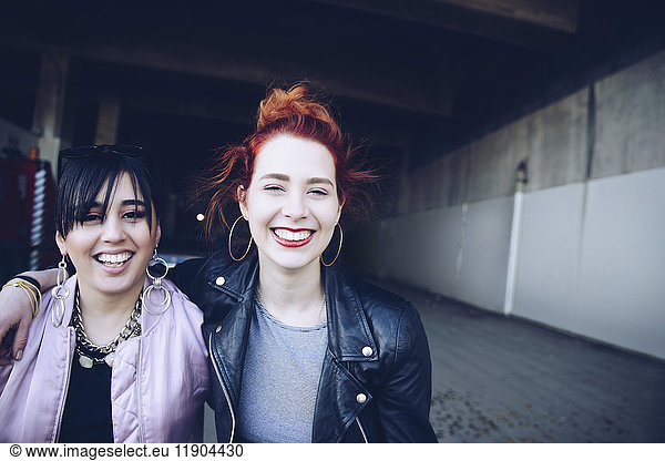 Portrait of smiling hipster female friends at parking lot