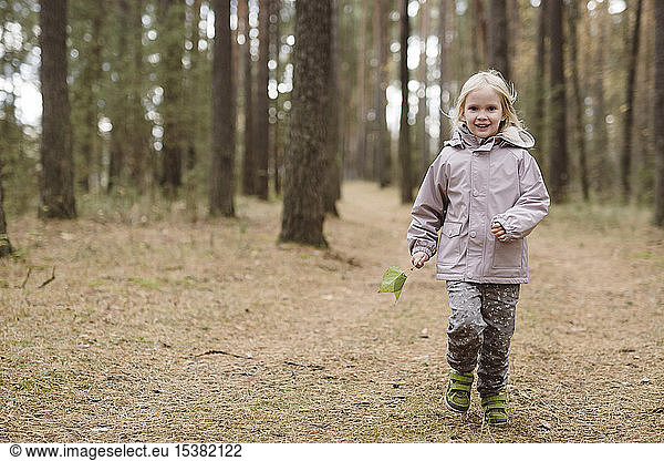 Portrait of smiling little girl in the woods