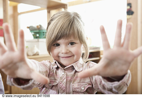 Portrait of smiling little girl showing her hands