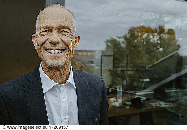 Portrait of smiling male entrepreneur outside office