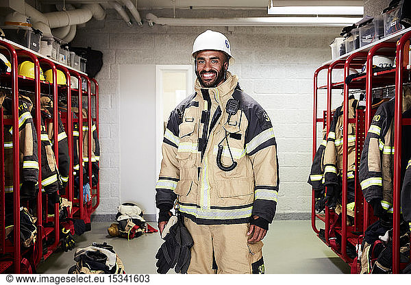 Portrait of smiling male firefighter in locker room at fire station