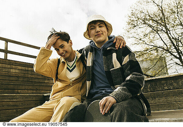 Portrait of smiling male friends sitting together on steps