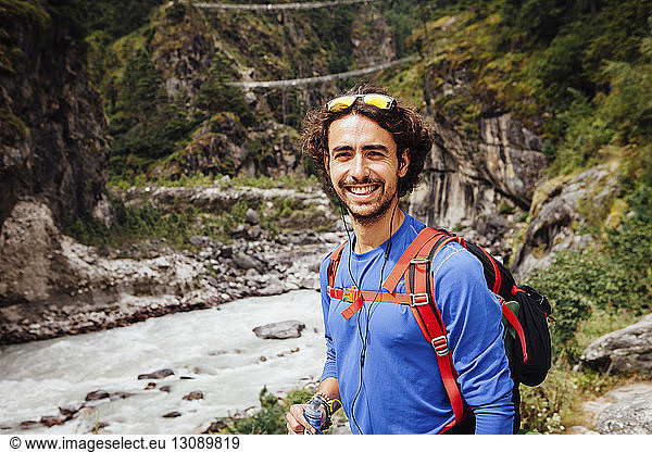 Portrait of smiling male hiker standing by river at Sagarmatha National Park