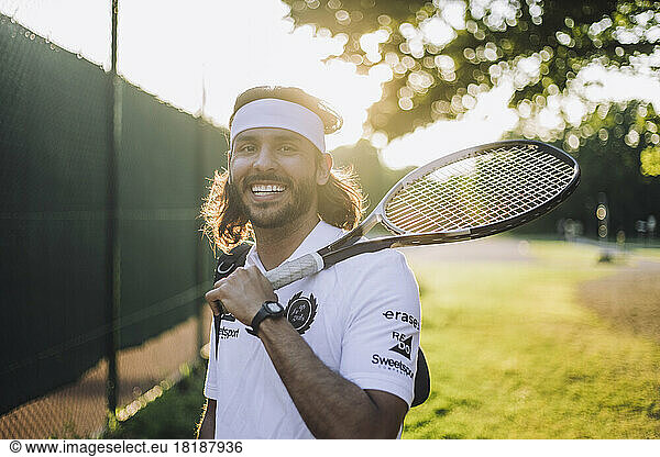 Portrait of smiling man holding tennis racket