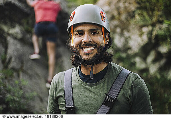 Portrait of smiling man wearing sports helmet during rock climbing